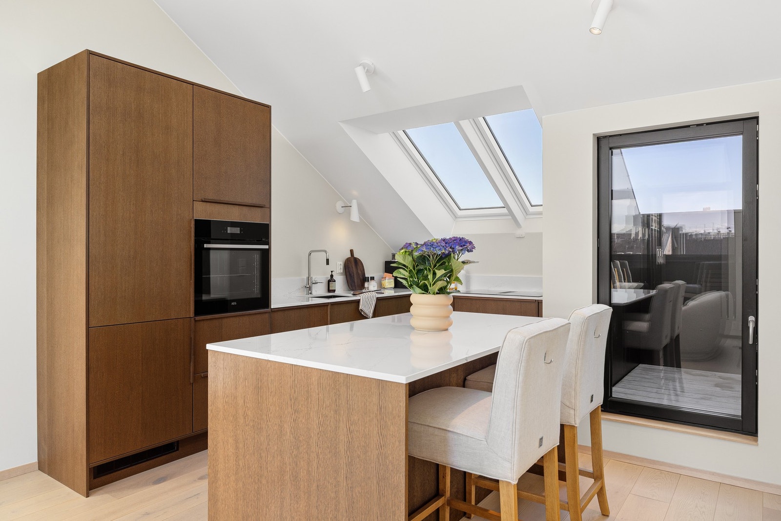 Eksklusivt kjøkken med praktisk kjøkkenøy med barløsning som gir et naturlig skille mot stue Galleribilde