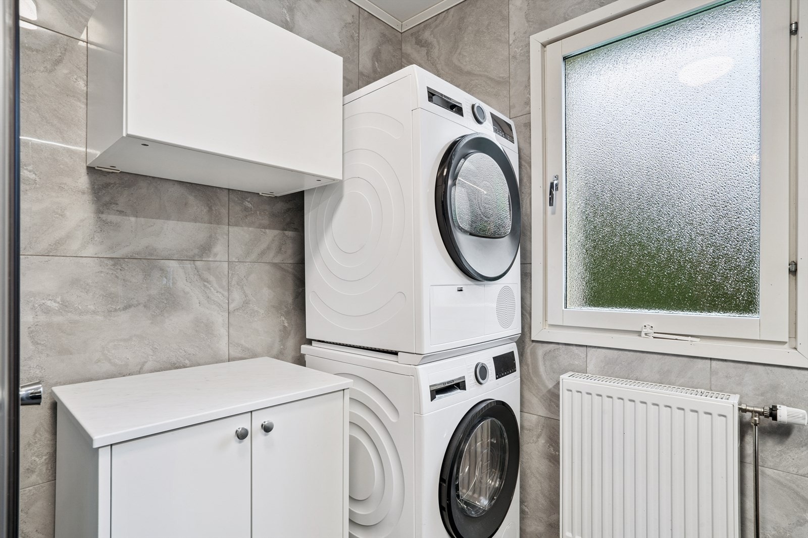 Rommet er praktisk innredet med opplegg for vaskemaskin og tørketrommel. Galleribilde