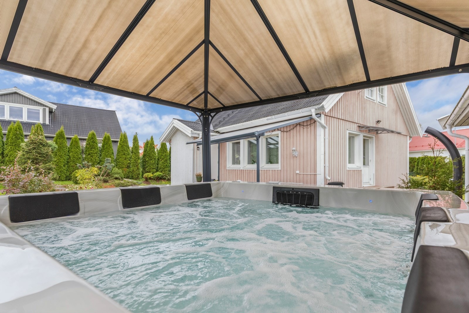 Ved siden av garasjen er det etablert et overbygg på 12 m² for jacuzzi. Jacuzzi medfølger salget. Galleribilde