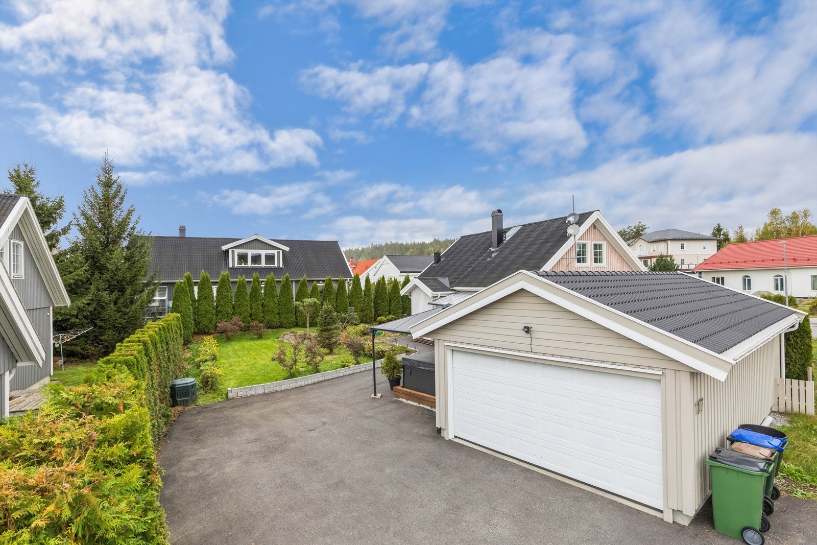 Den frittstående dobbeltgarasjen fra 2019 har en praktisk boddel og elektrisk port. Galleribilde