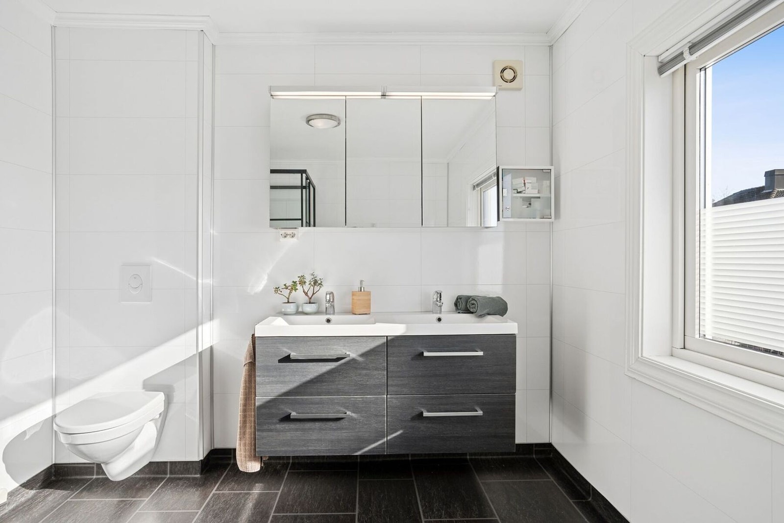 Praktisk innredet med dobbel servant, badekar, dusjkabinett og vegghengt toalett Galleribilde