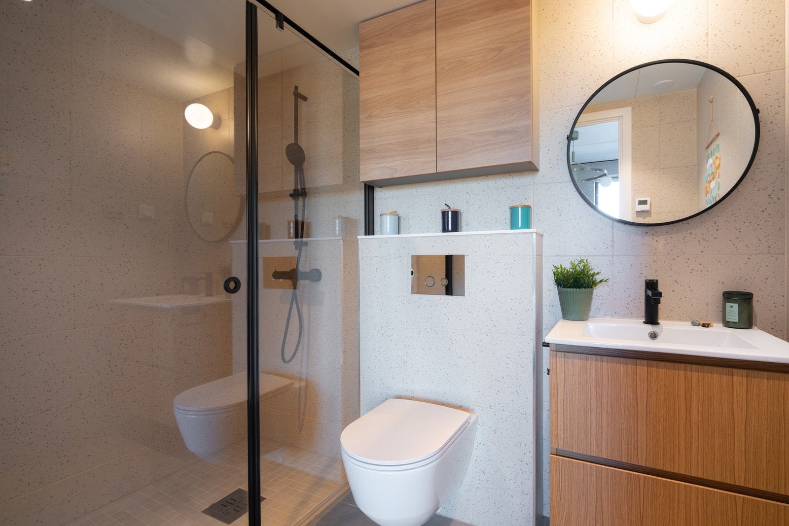 Det er baderomsinnredning med to skuffer og ovenpåliggende servant, samt speil og belysning over. I tillegg er badet utstyrt med eget dusjhjørne. Galleribilde