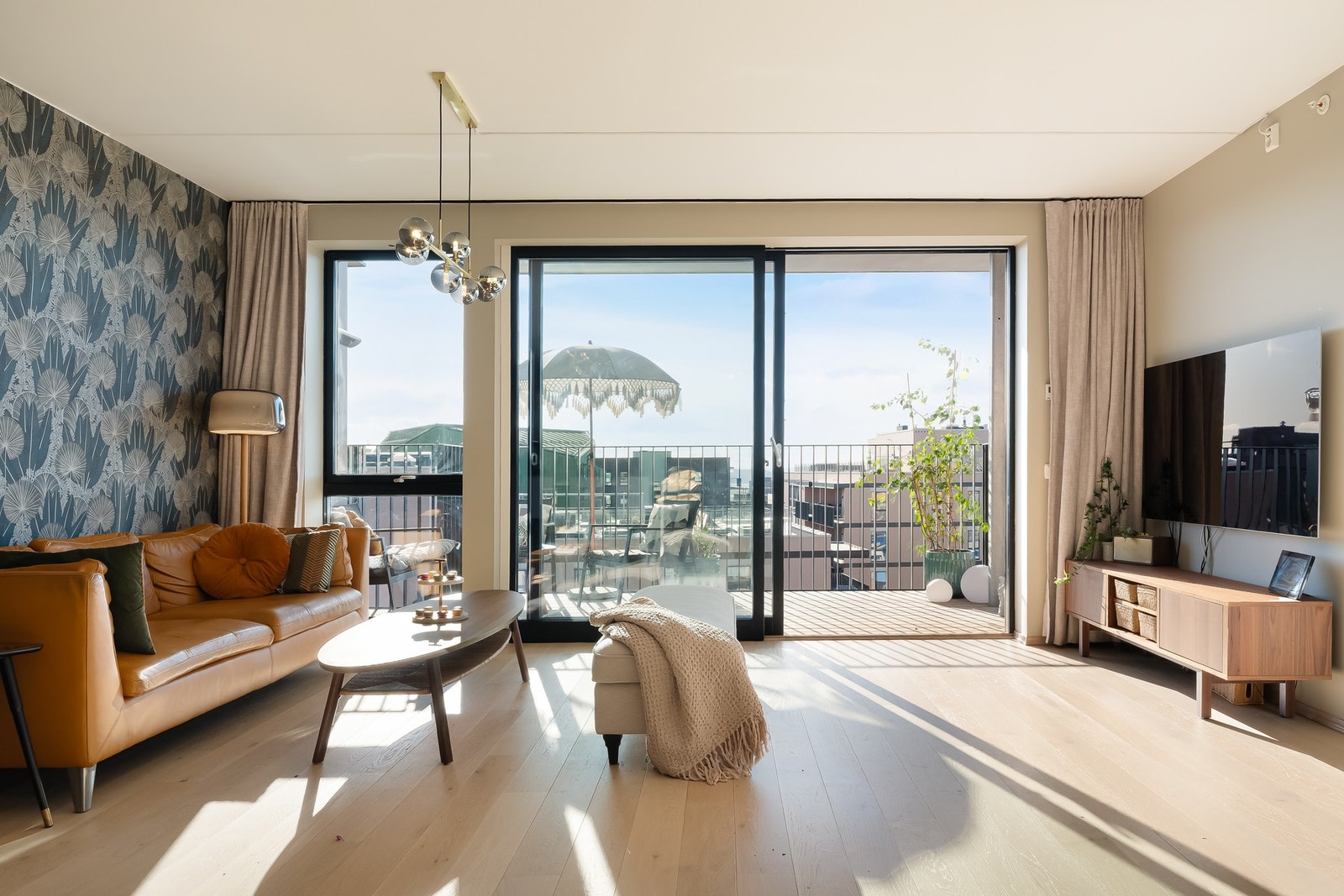 Stuen og kjøkkenet ligger i en åpen løsning og får godt med naturlig lys fra generøse vindusflater. Galleribilde