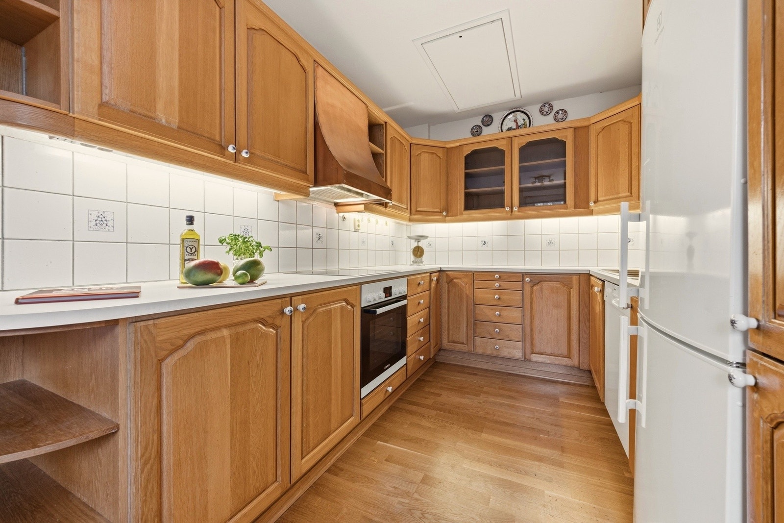 Leilighetens kjøkken har profilerte fronter og frittstående hvitevarer. Galleribilde