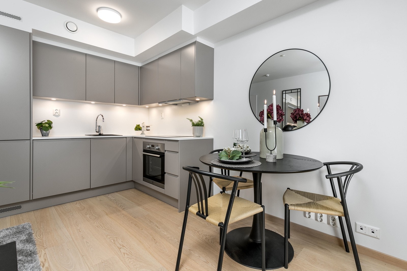 Lekkert kjøkken i åpen løsning mot stue, med integrerte hvitevarer Galleribilde