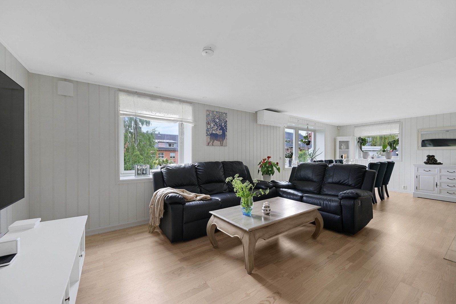 Stuen fremstår som trivelig og lys og kan romme sitteplass til hele familien Galleribilde