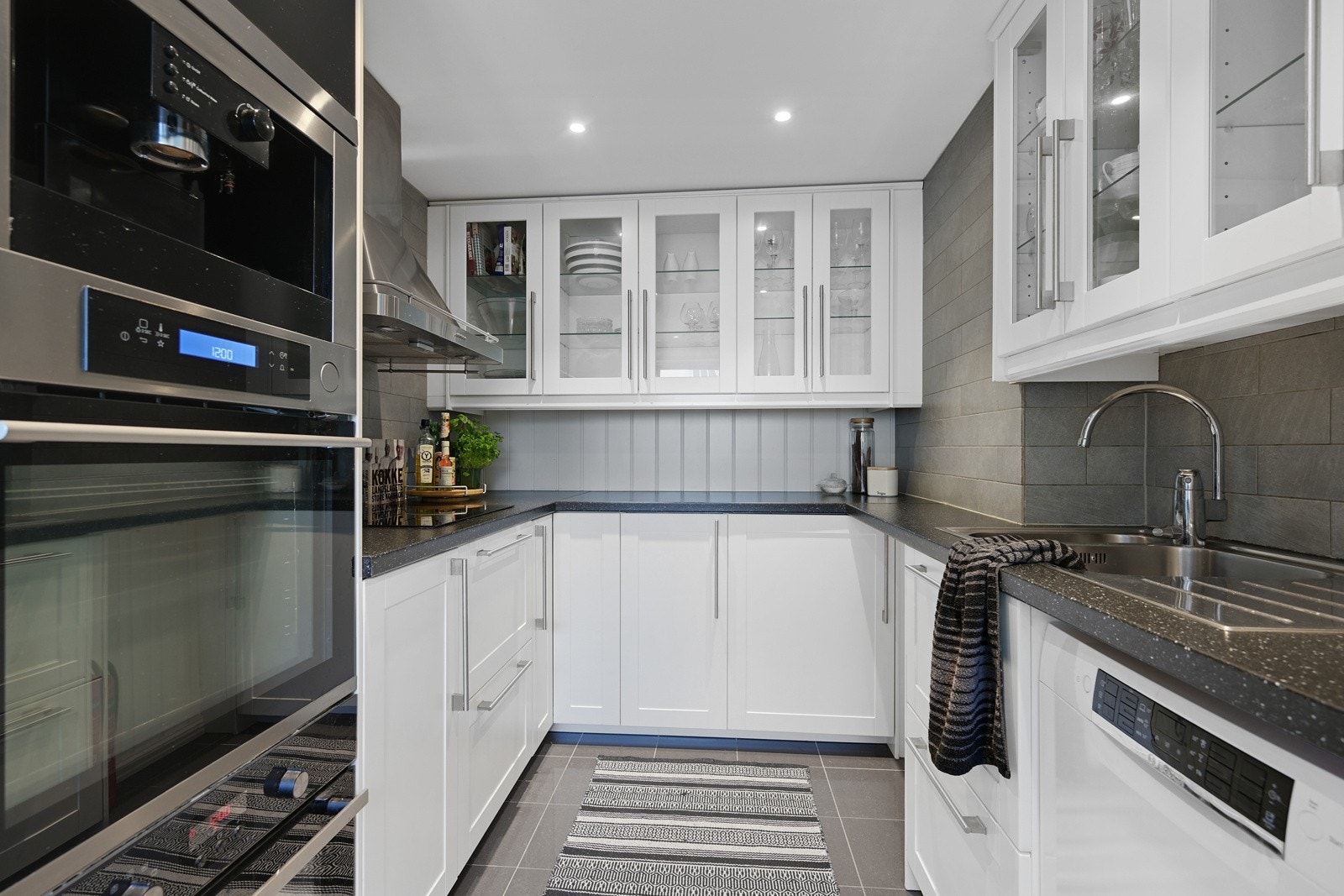 Lekkert kjøkken med pene fliser på både gulv og vegg Galleribilde