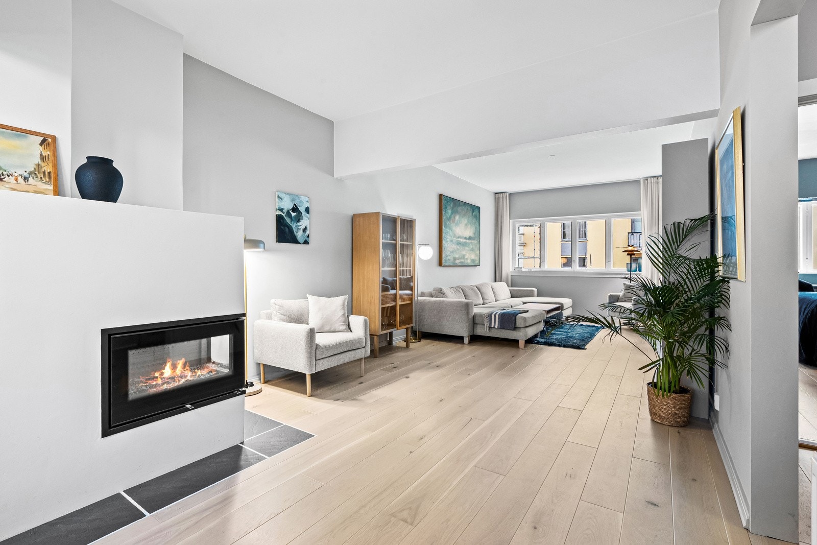 Stor og romslig stue med peis og plass til flere møbleringssoner Galleribilde