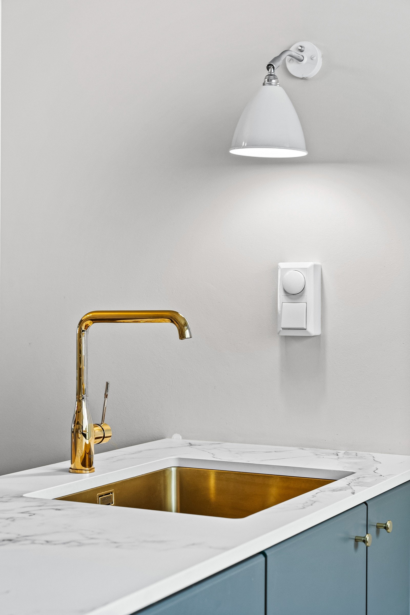 Den lyse komposittstein-benkeplaten har en underlimt kum og et stilrent ett-greps armatur i messing, som tilfører et eksklusivt preg Galleribilde