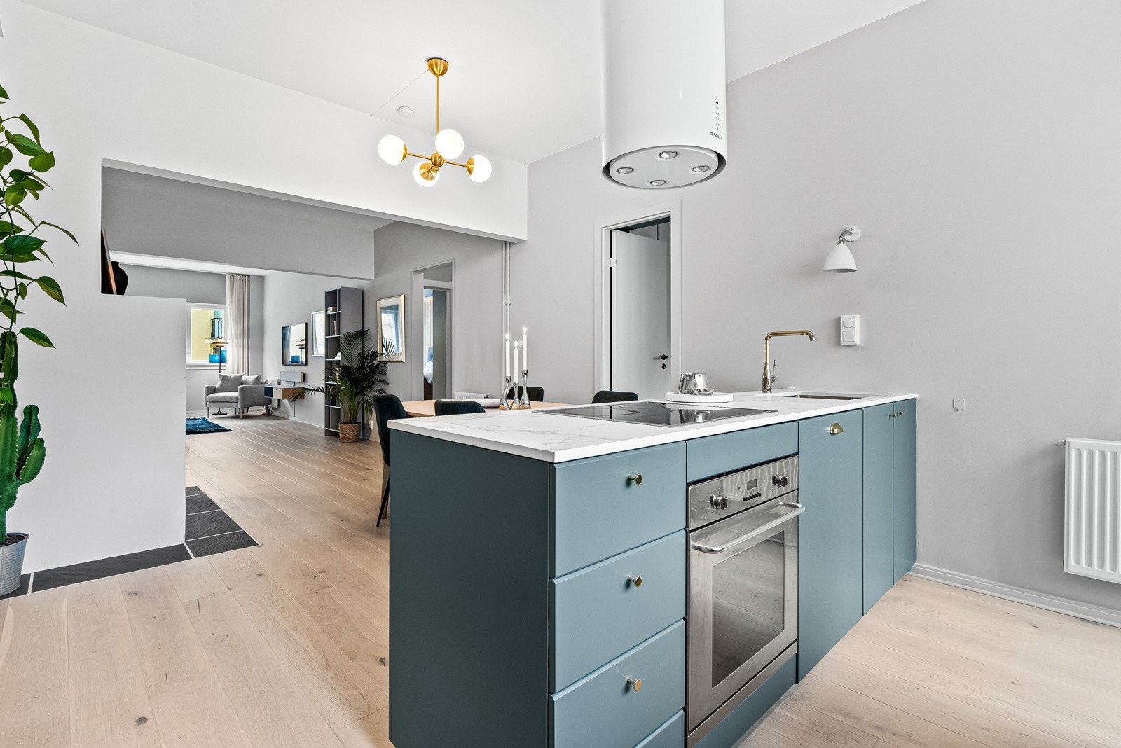 Det stilrene og åpne kjøkkenet er utformet med praktiske løsninger og rikelig oppbevaringsplass Galleribilde