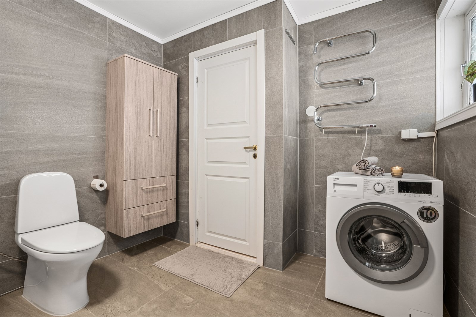 Badet har opplegg og plass for vaskemaskin. Galleribilde