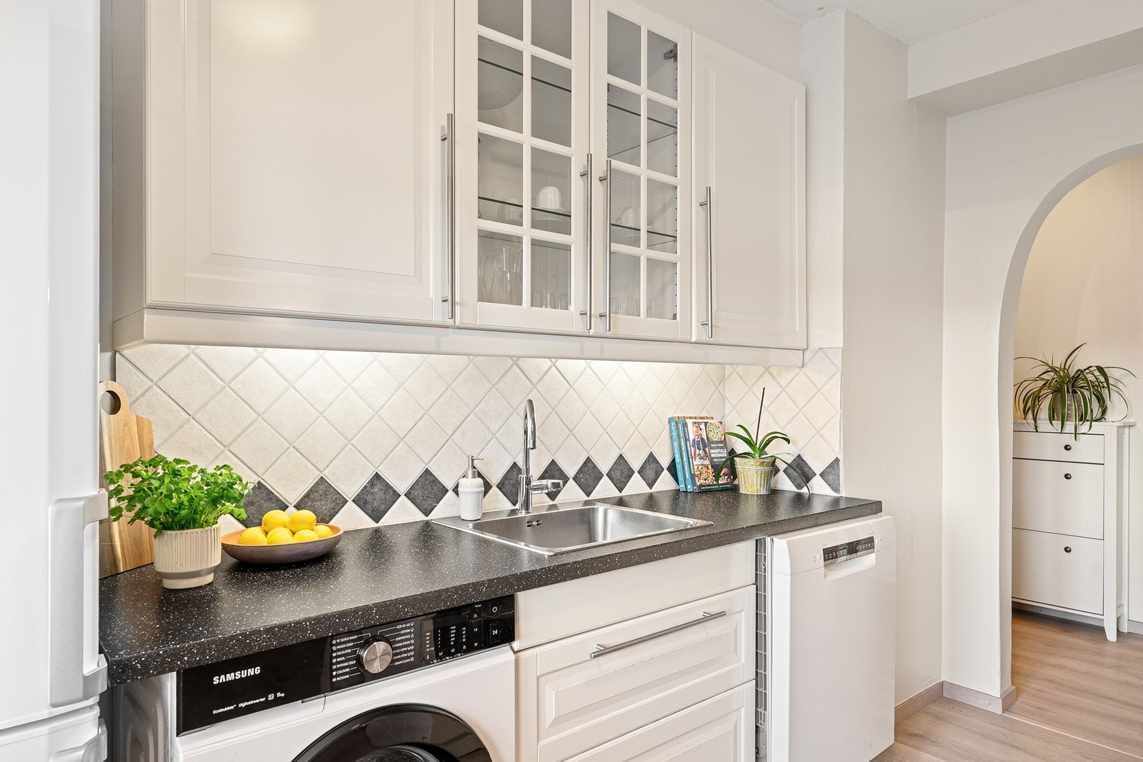 Kjøkkenet ligger naturlig tilbaketrukket fra stuen og har klassiske fronter og flislagt vegg over benk - som gir et tidløst og velholdt uttrykk. Galleribilde