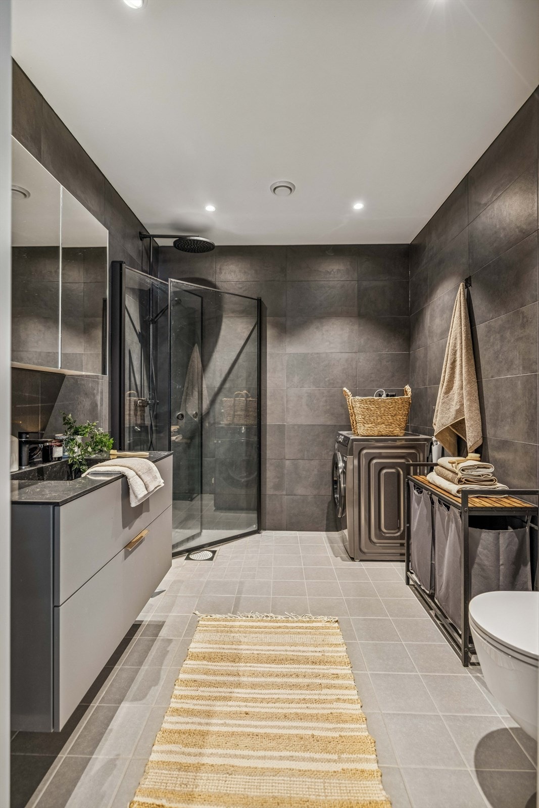 Rommet er utstyrt med dusjhjørne med glassdører og har opplegg for vaskemaskin. Galleribilde