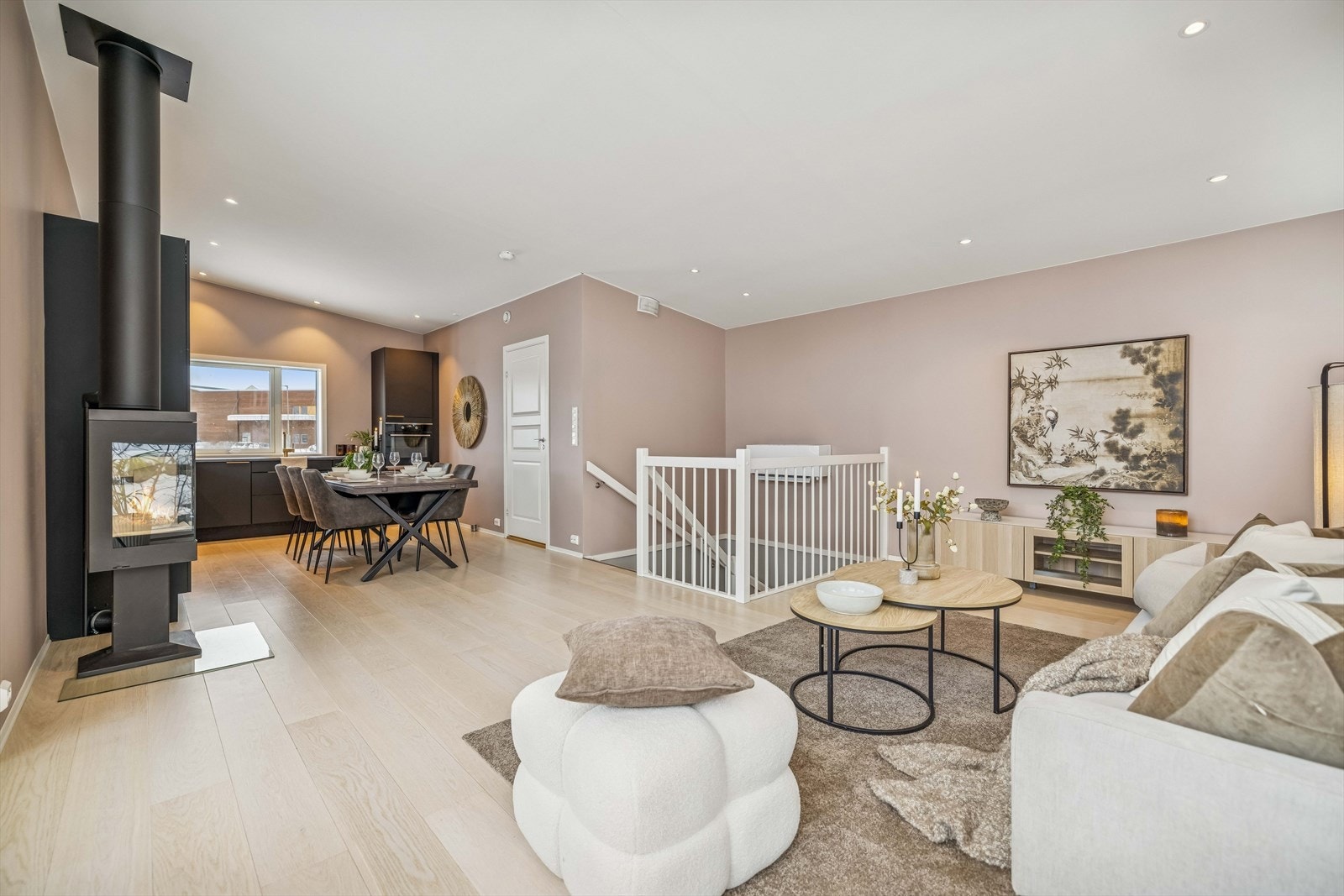 Et sosialt allrom med lakkert eiketrapp som binder etasjene sammen. Galleribilde