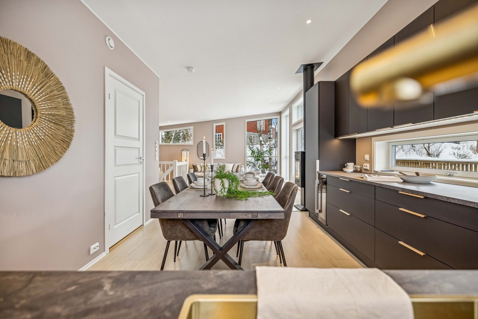 Kjøkkenet har en sort innredning med glatte fronter og en slitesterk laminatbenkeplate. Galleribilde