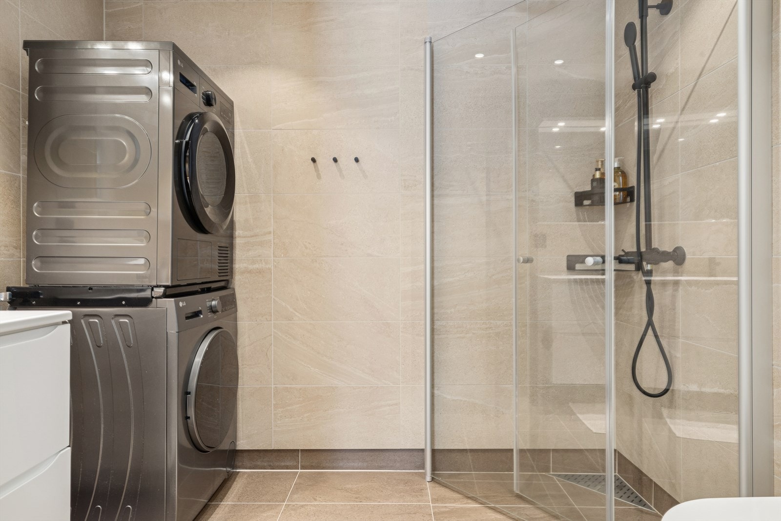 Innredningen består av servant på underskap med skuffer, speilskap med belysning, dusjhjørne med innfellbare glassvegger og vegghengt toalett. Det er også opplegg for vaskemaskin. Galleribilde