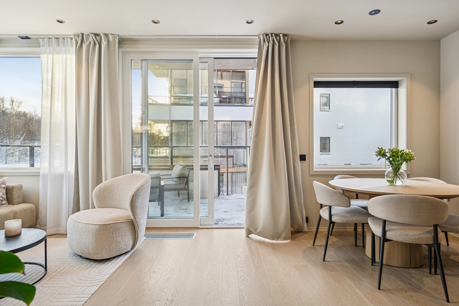 Moderne, åpen stue- og kjøkkenløsning med romslig plass til både en komfortabel sofagruppe og et innbydende spisebord. De store vindusflatene slipper inn rikelig med naturlig lys og gir direkte tilgang til balkongen. Galleribilde