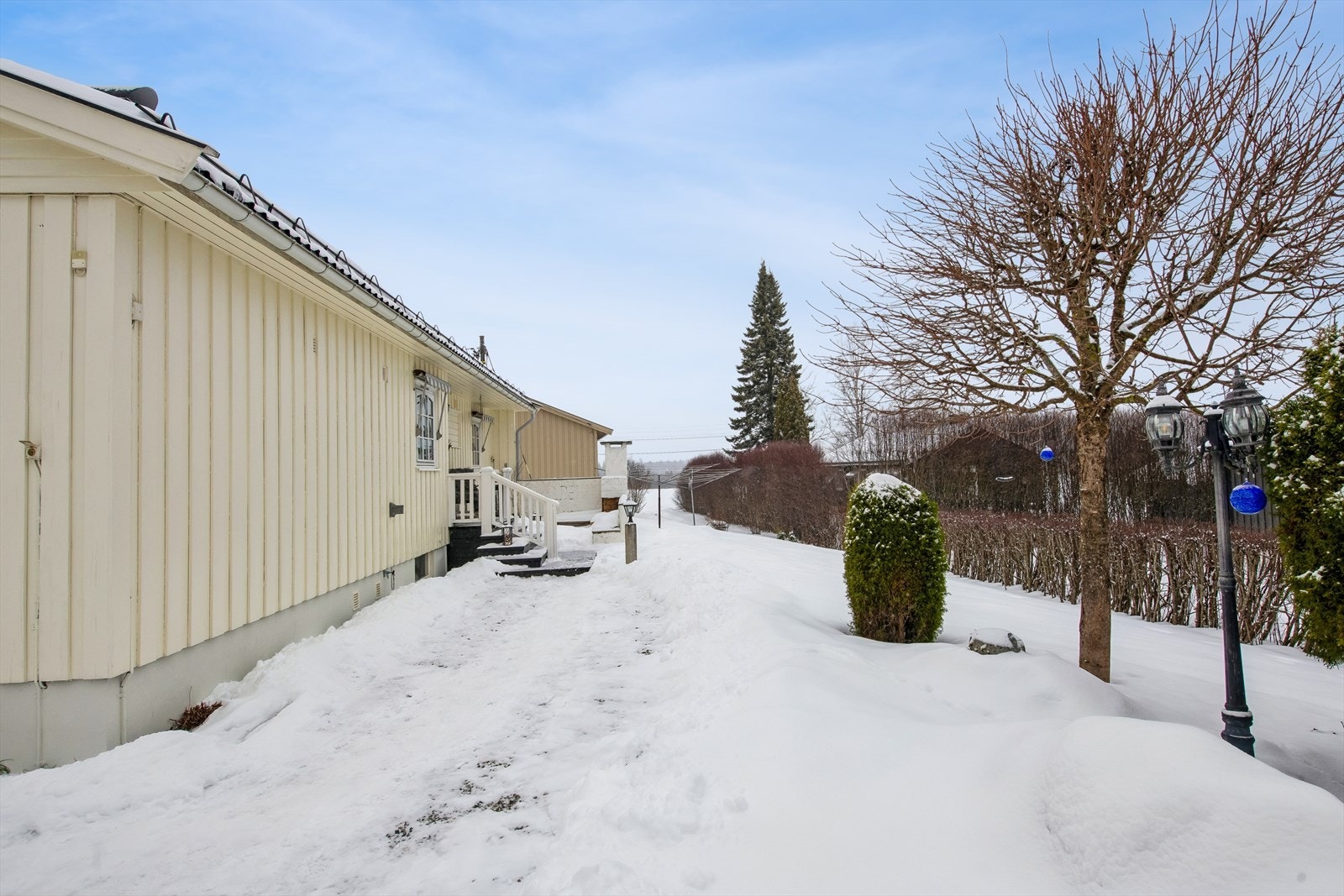 Eiendommen har en pent opparbeidet hage med gressplen og prydbusker. Galleribilde