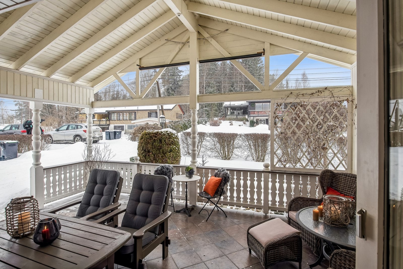 Takoverbygget terrasse i flislagt betong på 26 m² fra 2002, med malt rekkverk med stående profilerte bord og levegg på ene siden. Galleribilde