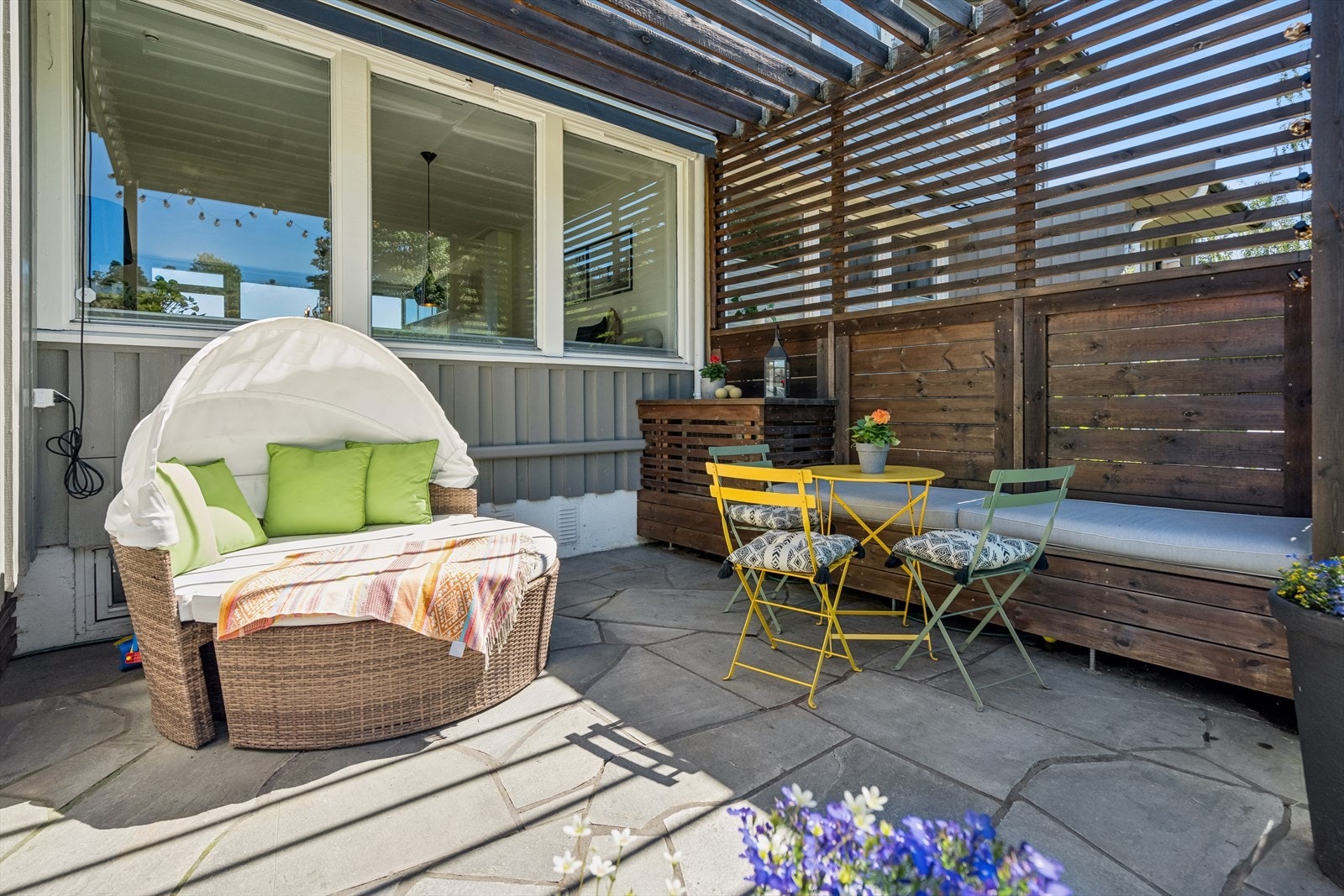 Uteplass på fremsiden av huset, med steinsatte arealer, pergola og markise. Utedel til varmepumpen er bygget inn og laget til med benk. En ordentlig sommerdrøm! Galleribilde