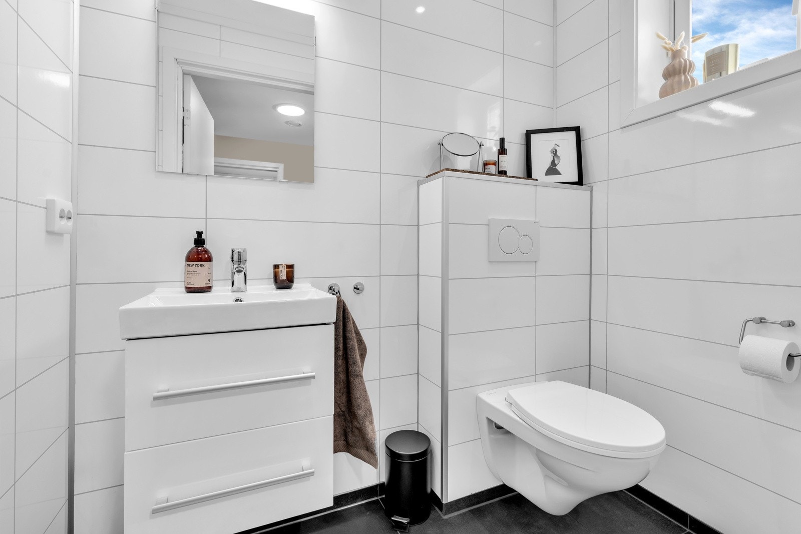 Toalettrom med fliser med varmekabler i gulv, vegghengt toalett og pen innredning. Galleribilde