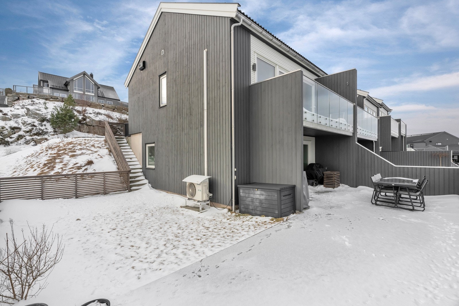 Uteområdet er pent opparbeidet med stor støpt platting og plen. Det går trapp ned til uteområdet fra inngangspartiet. Galleribilde