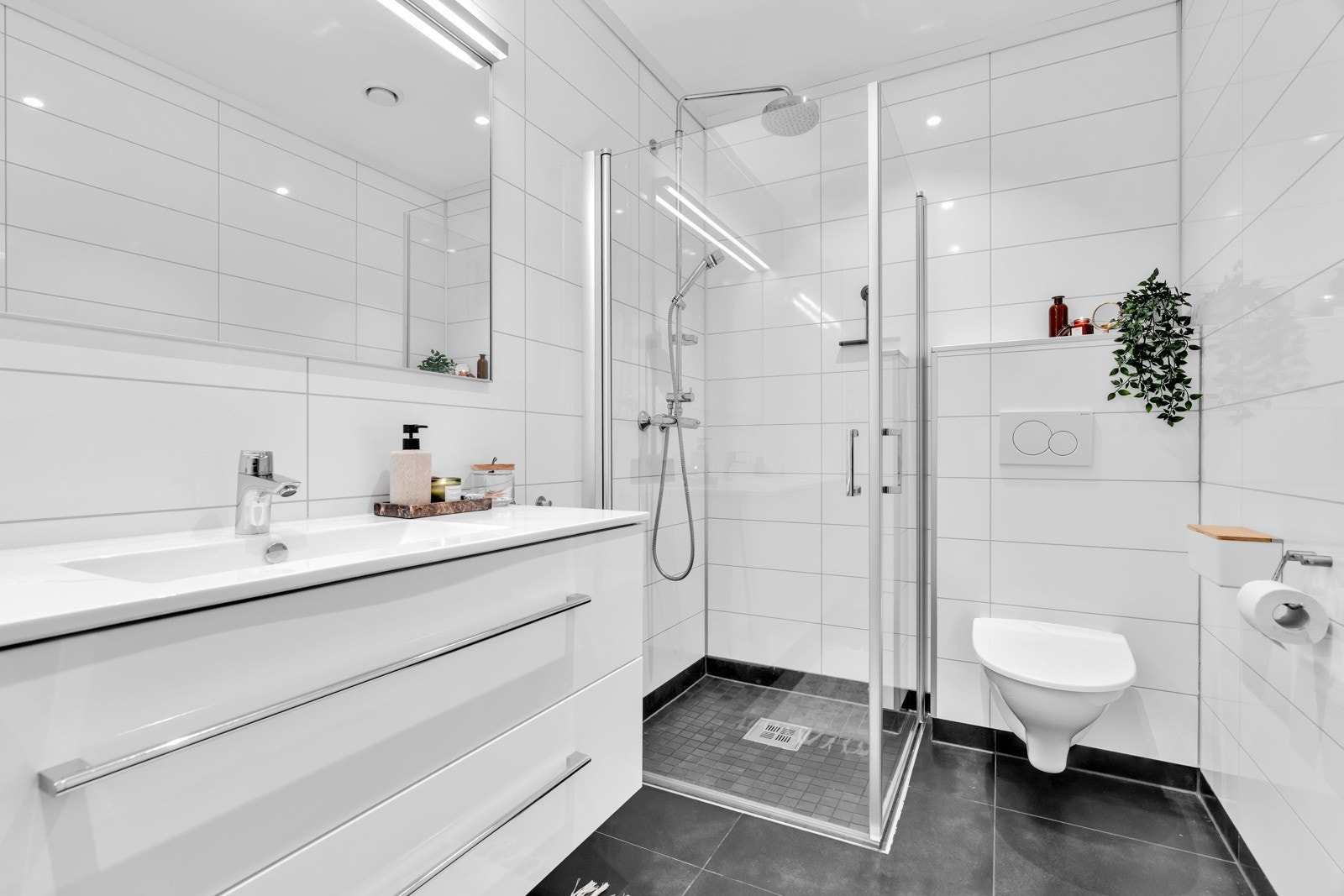 Badet har bl.a spotter i tak, vegghengt toalett, god innredning og dusjhjørne. Galleribilde