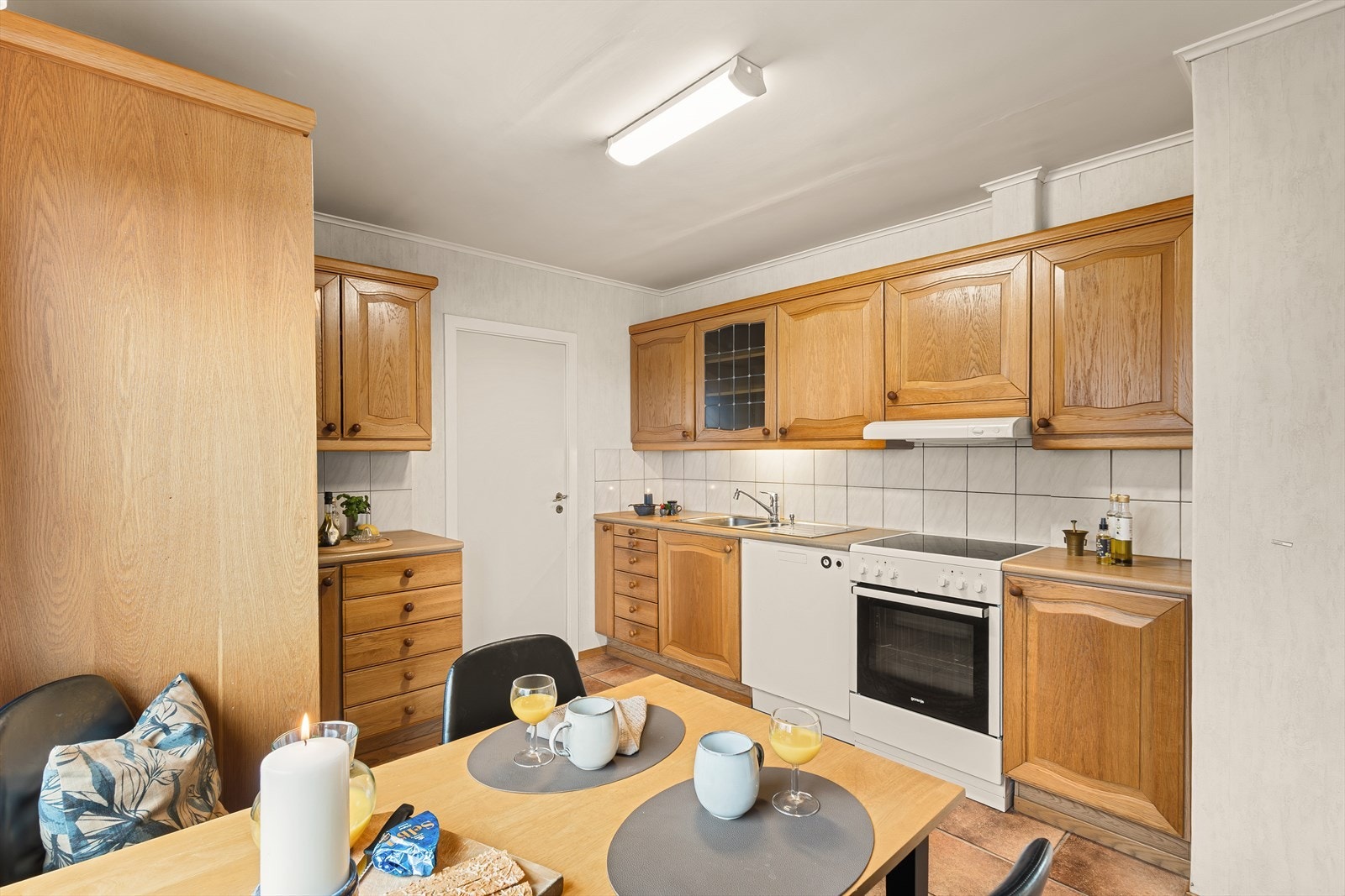 Kjøkkeninnredningen har profilerte fronter og laminat benkeplate med nedfelt oppvaskkum i rustfritt stål. Galleribilde