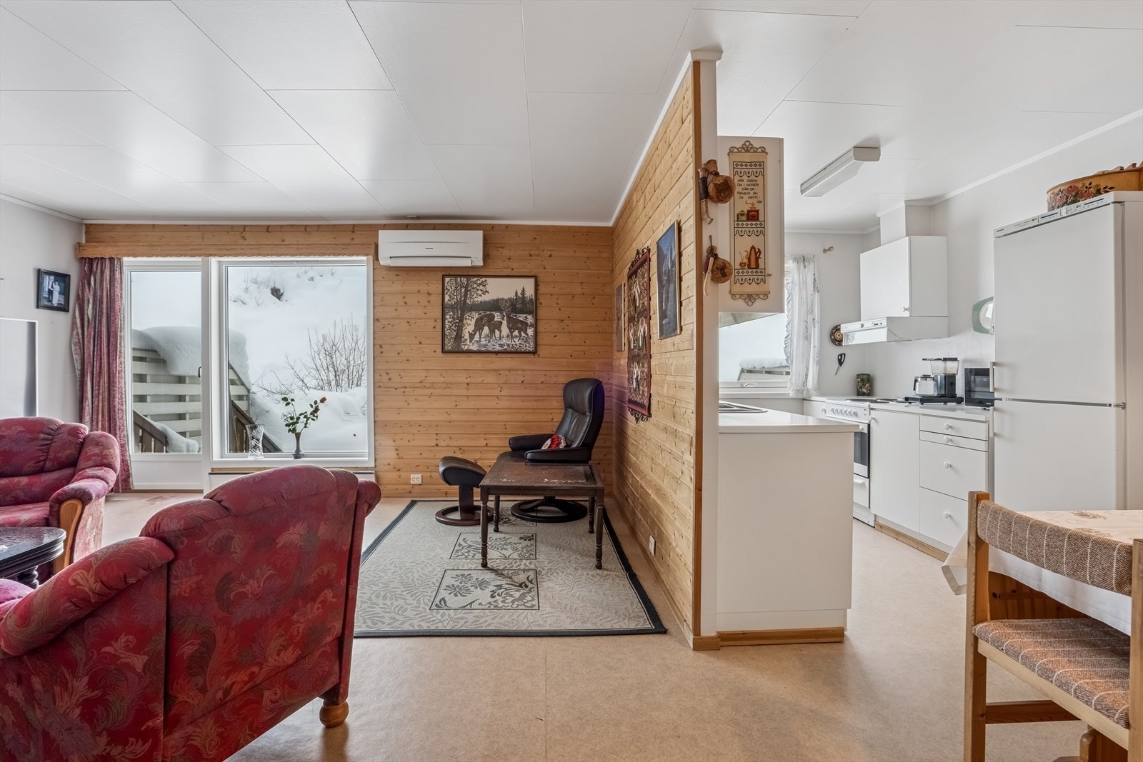 Treveggene gir stuen et varmt preg, mens store vinduer gir godt med naturlig lys. Galleribilde