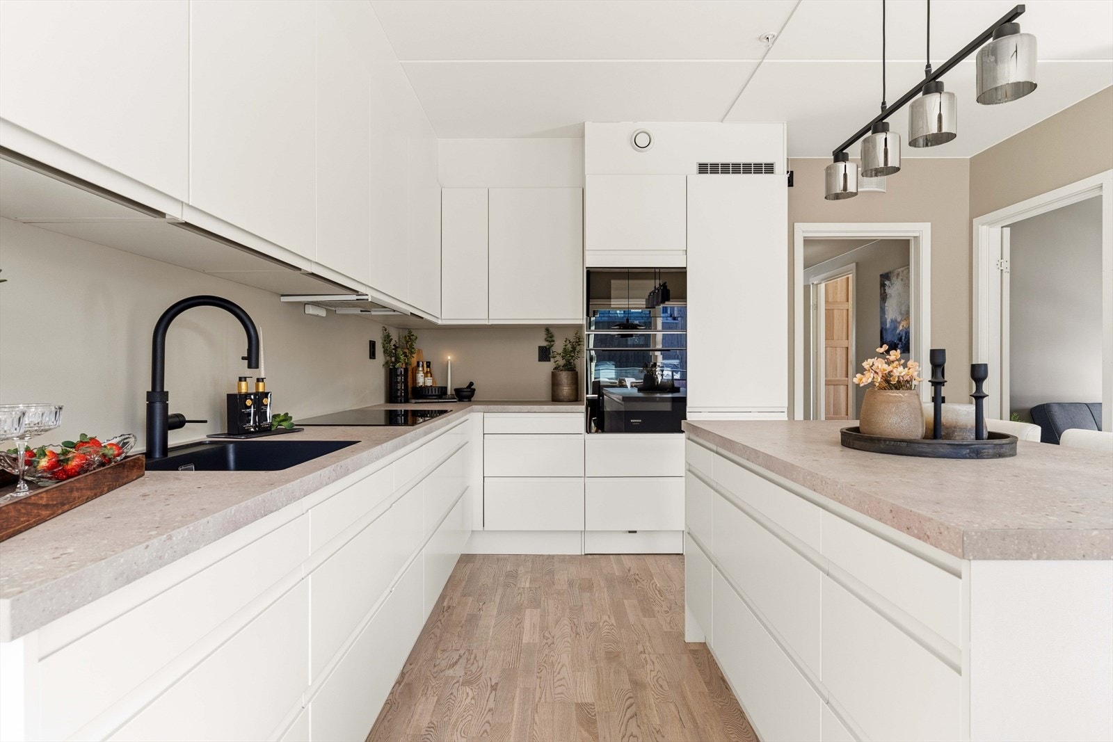 Kjøkkenet byr på rikelig med skapplass og en praktisk kjøkkenøy. Et moderne samlingspunkt i boligen. Galleribilde