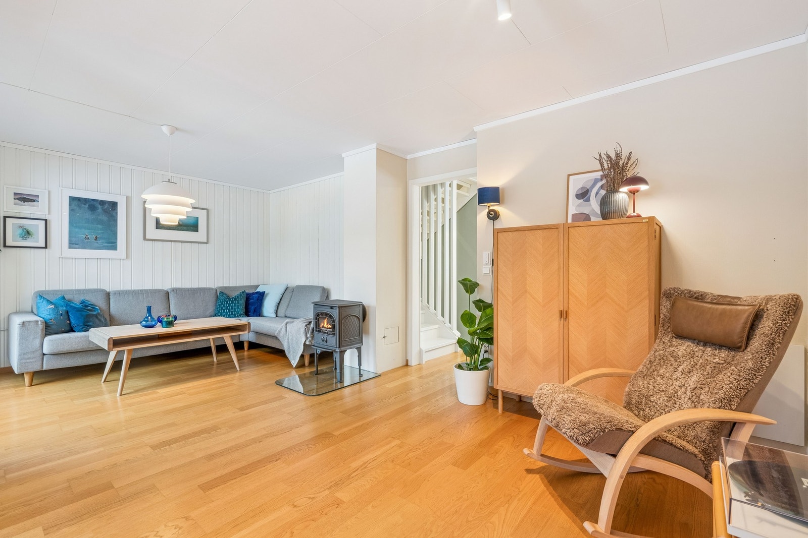 Videre finner du en lys og romslig stue med vedfyring. Galleribilde