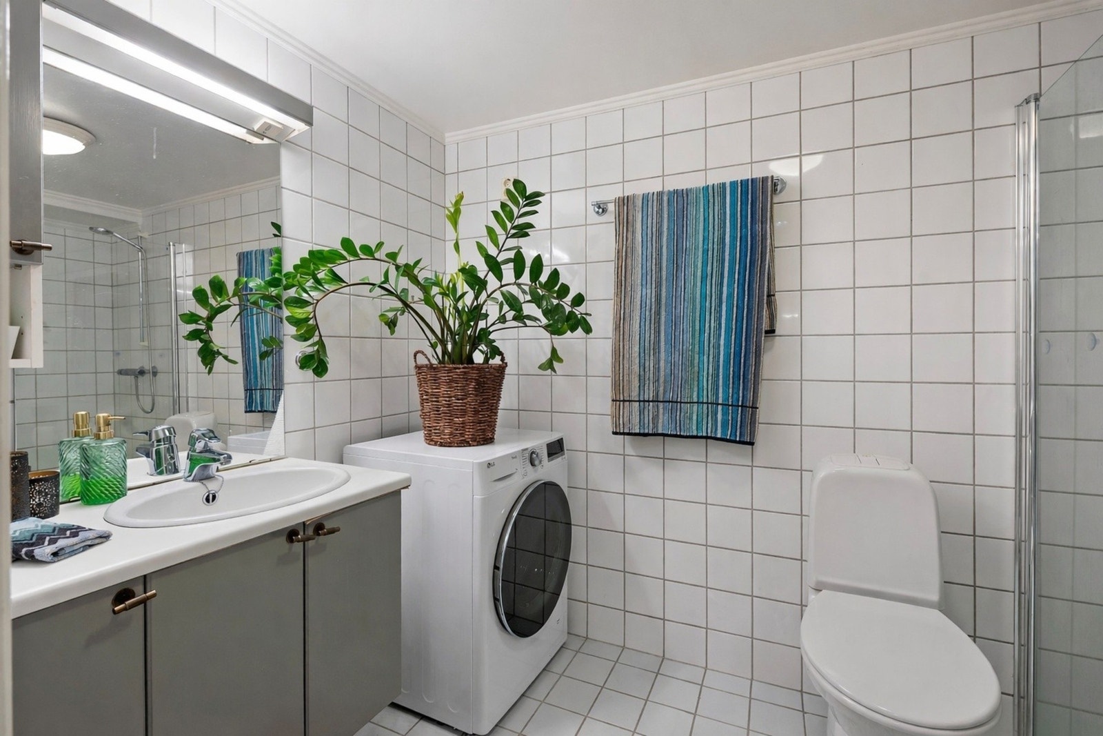 Pent flislagt bad med avsatt plass til vaskemaskin Galleribilde