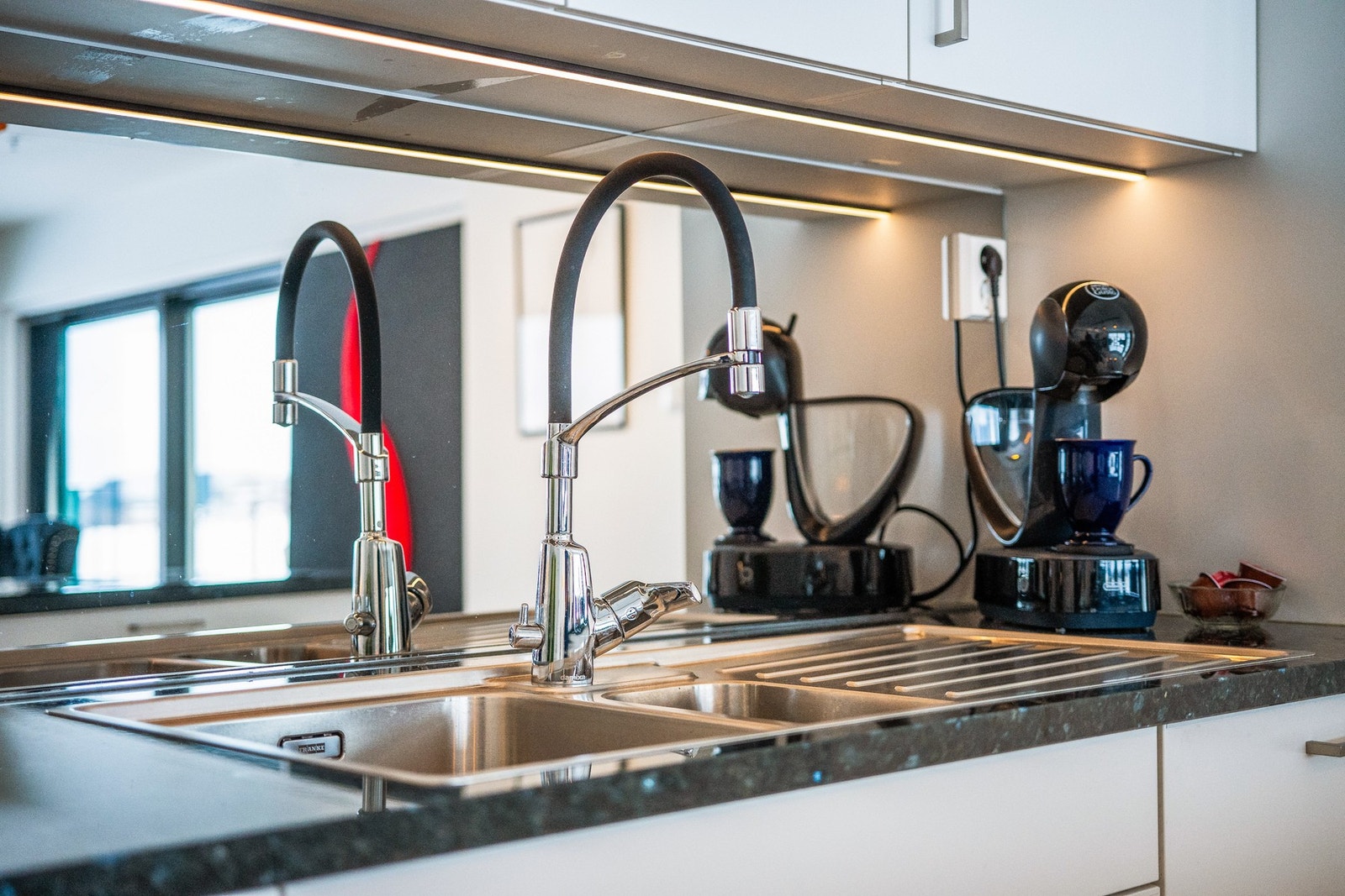 Tøffe detaljer i leiligheten med bl.a dette kjøkkenarmaturet og speilglasset mellom benken overskapene Galleribilde