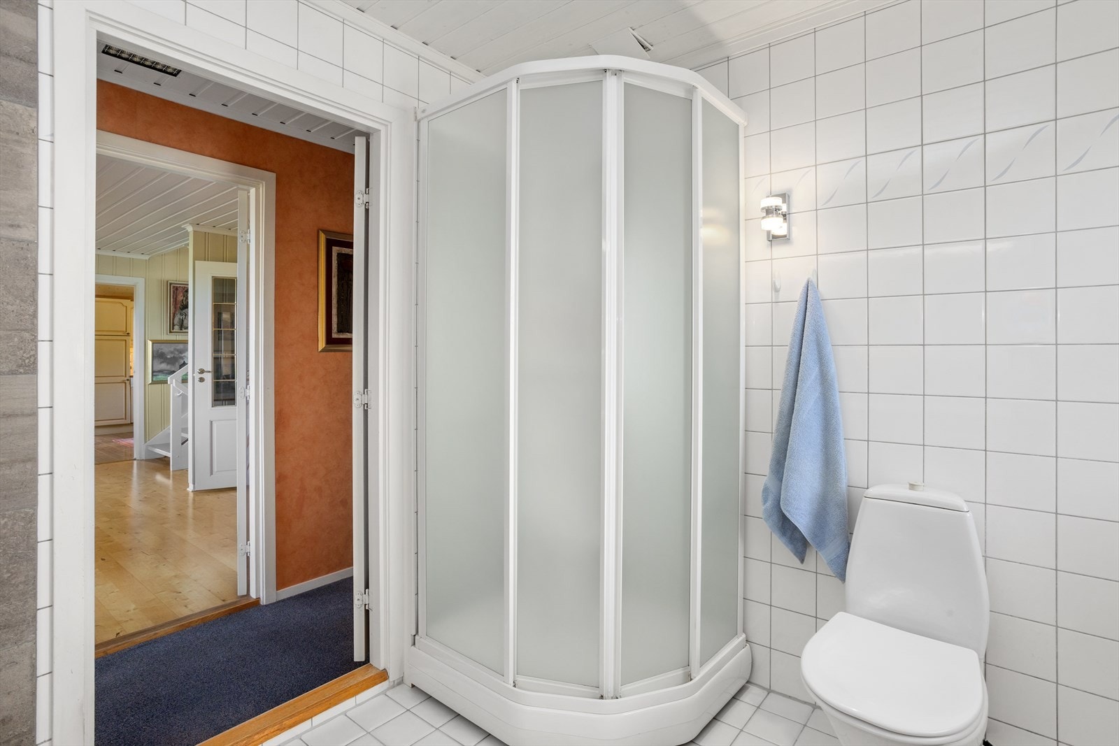 Badet har flislagt gulv, varmekabler og dusjkabinett. Galleribilde