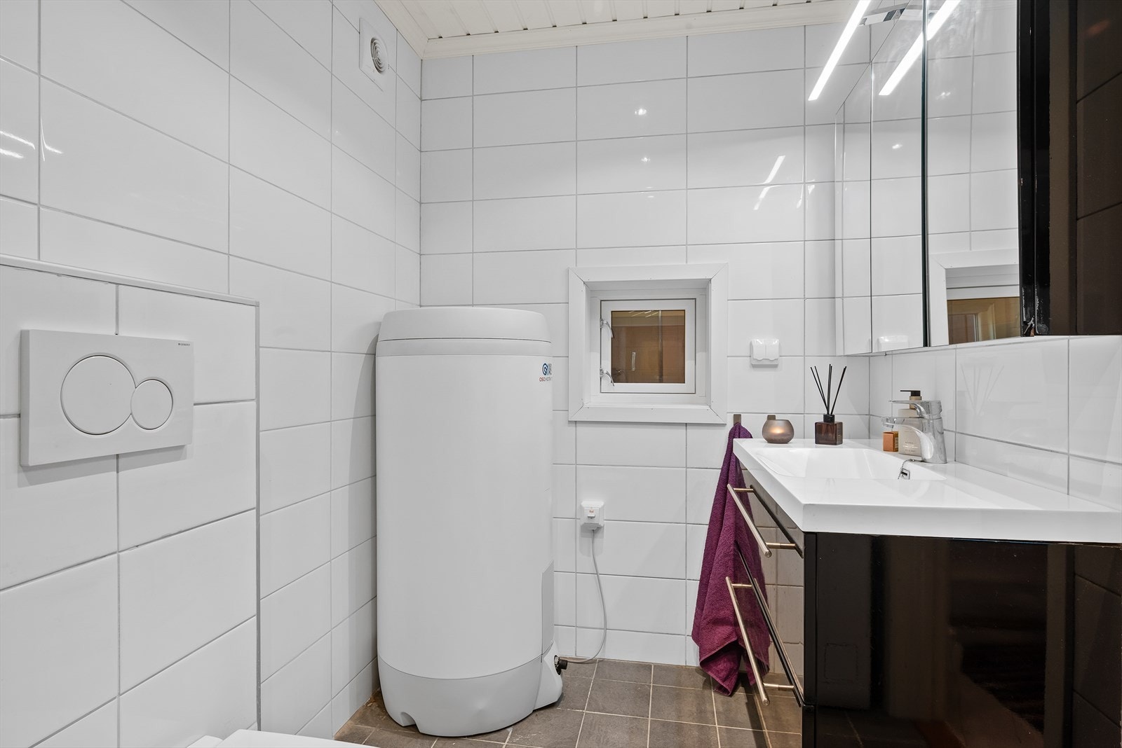 Dagene får en god start på et helfliset bad med varmekabler, downlights og vegghengt toalett. Galleribilde