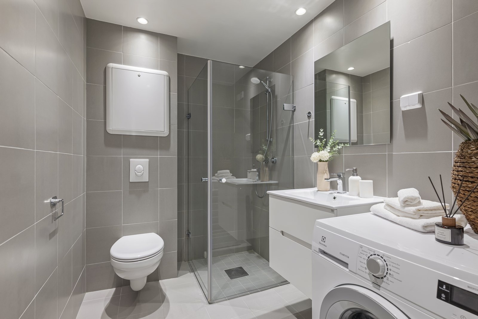 Pent bad fra 2015 med fliser på både vegg og gulv, varmekabler, dusjsone, vegghengt toalett og plass/opplegg for vaskemaskin. Galleribilde