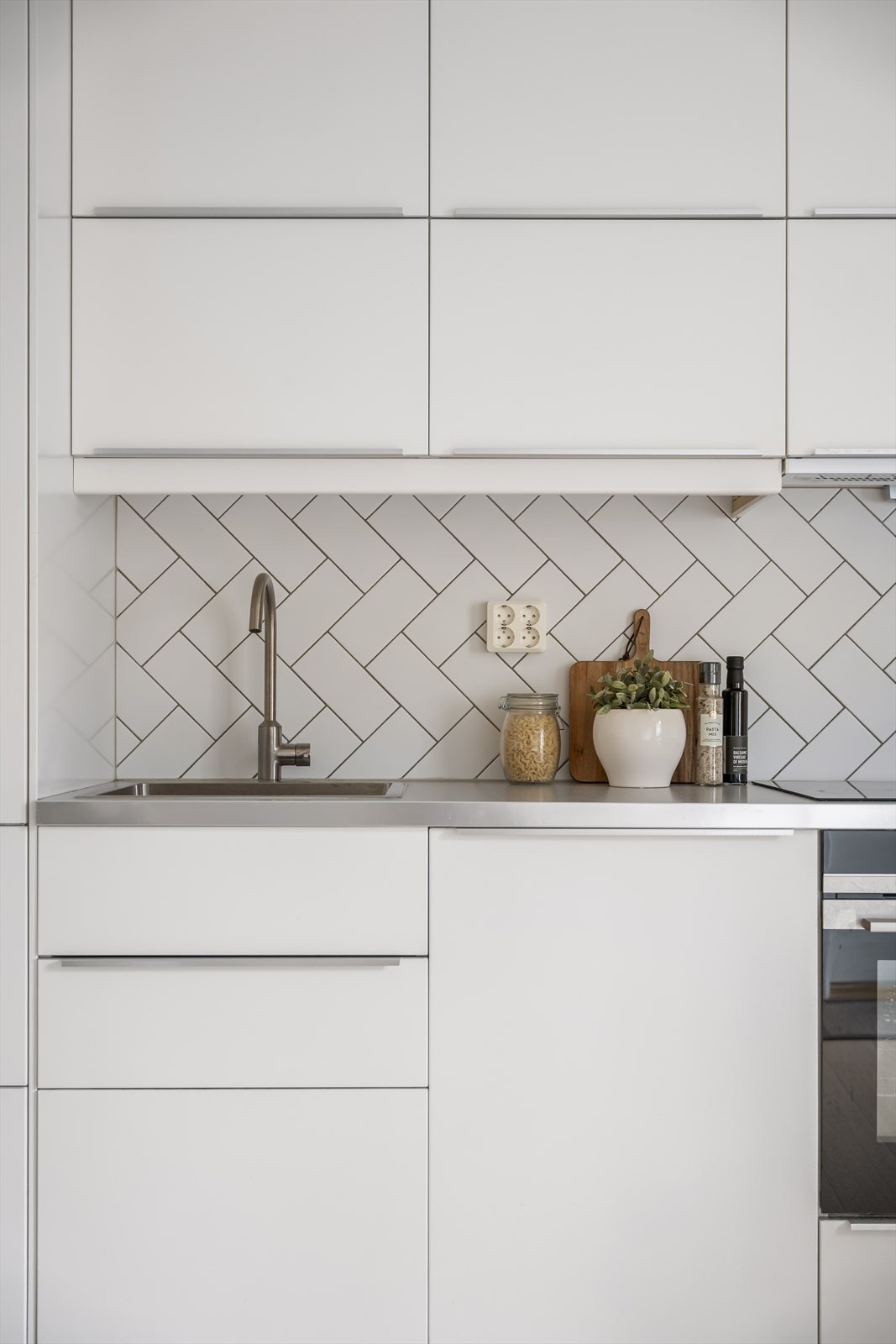 Gode oppbevaringsløsninger med glatte fronter, laminert benkeplate og integrerte hvitevarer gjør kjøkkenet både praktisk og stilrent. Galleribilde