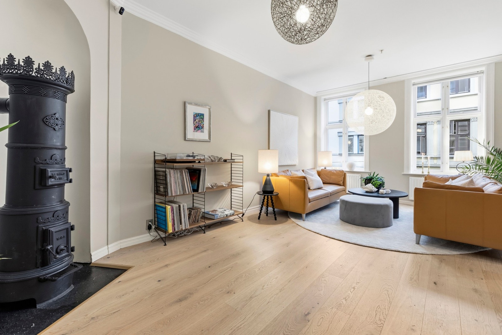 Stuen i leiligheten oppleves som lys og romslig med store vindusflater som slipper inn rikelig med naturlig lys og skaper en luftig atmosfære. Galleribilde