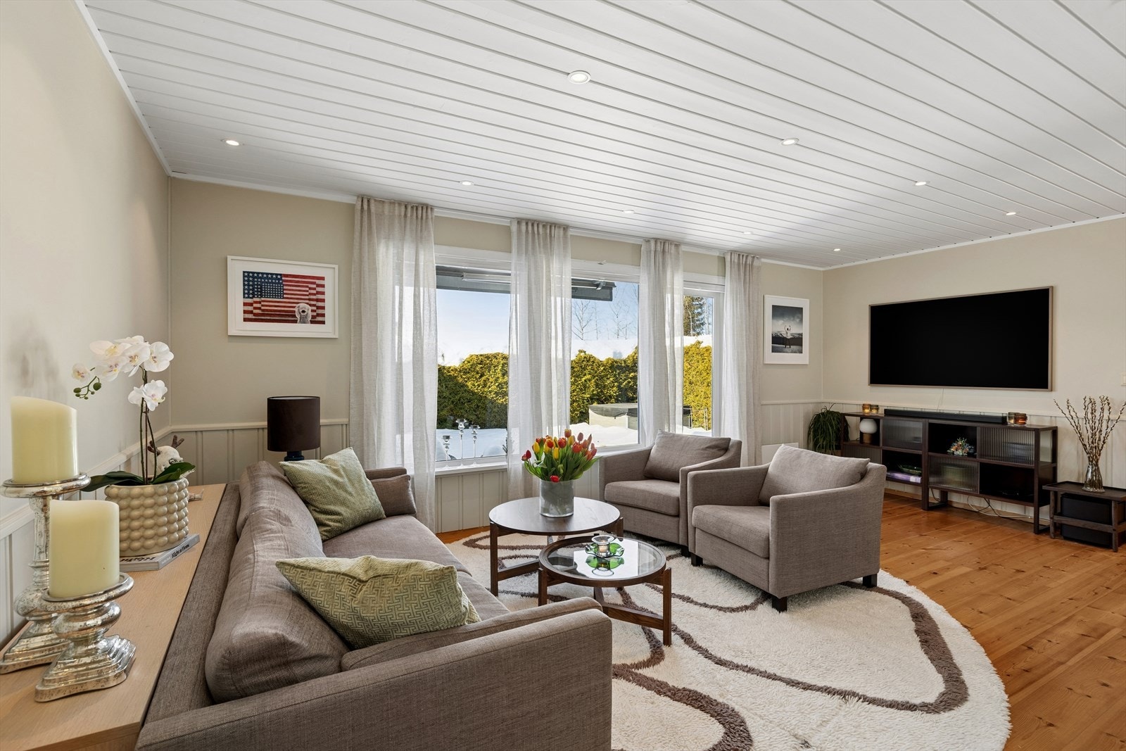 Stuen har lysmalte vegger og panel i taket med downlightbelysning. Galleribilde