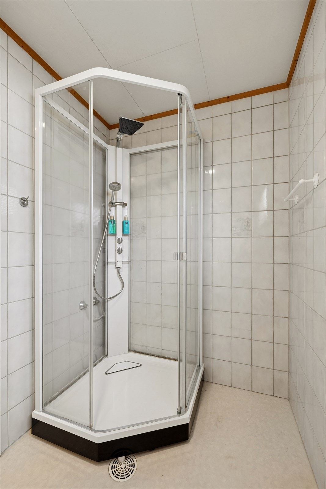 Baderommet er innredet med dusjkabinett, gulvmontert toalett og servant med skuffer. Galleribilde