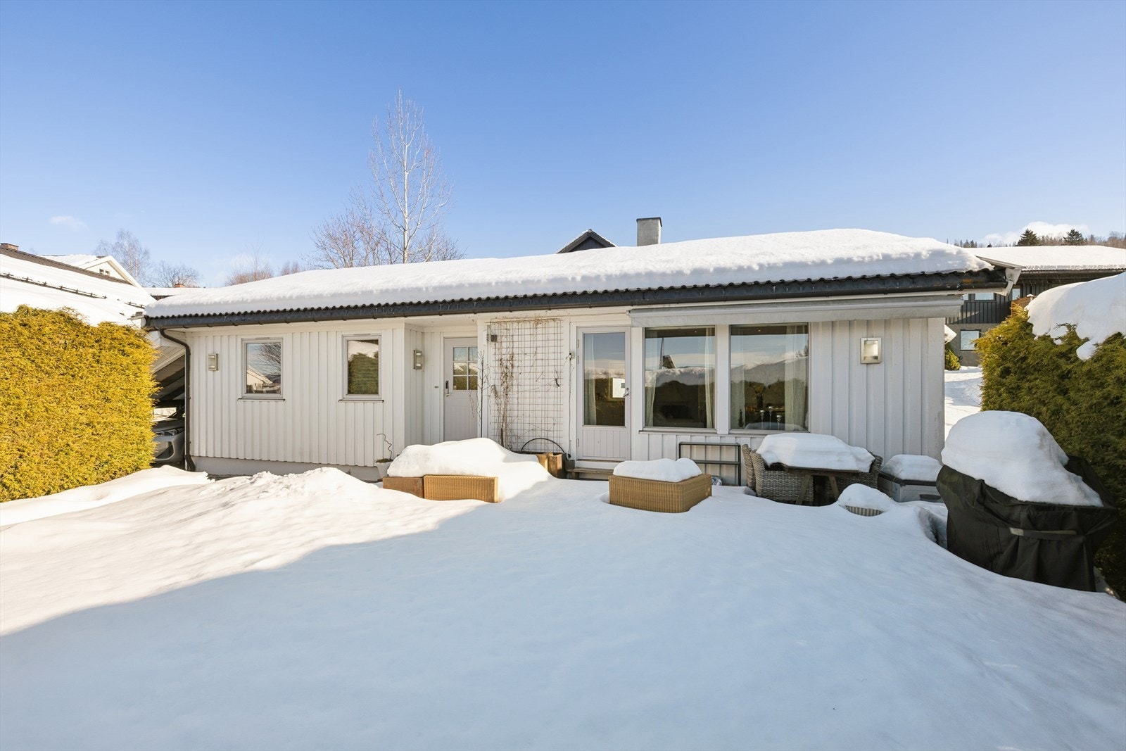 Terrasse utenfor stue med fin plass til hagemøbler. Galleribilde