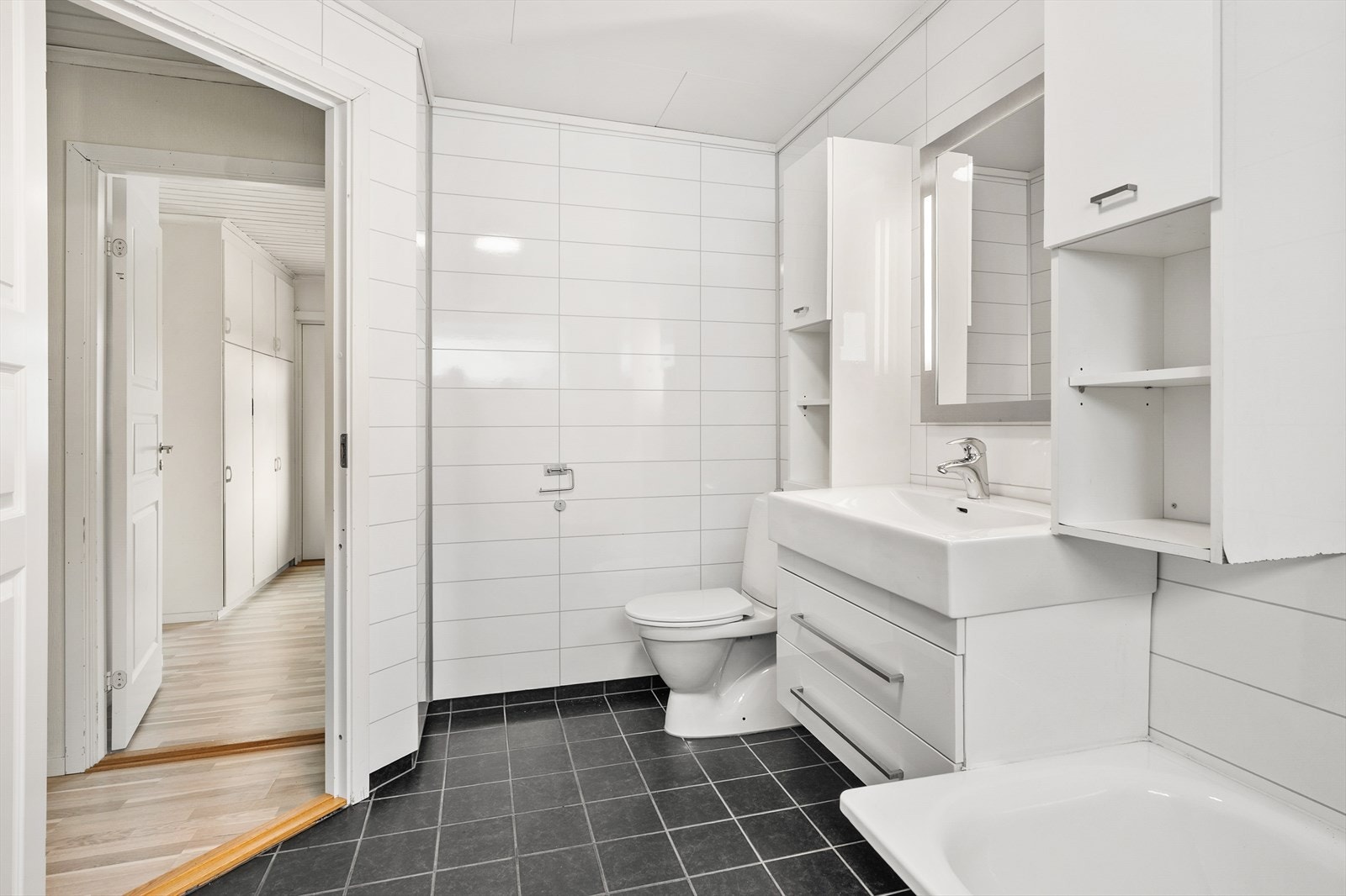 Bad er utstyrt med innredning som inkluderer nedfelt servant, toalett, badekar og opplegg for vaskemaskin. Galleribilde