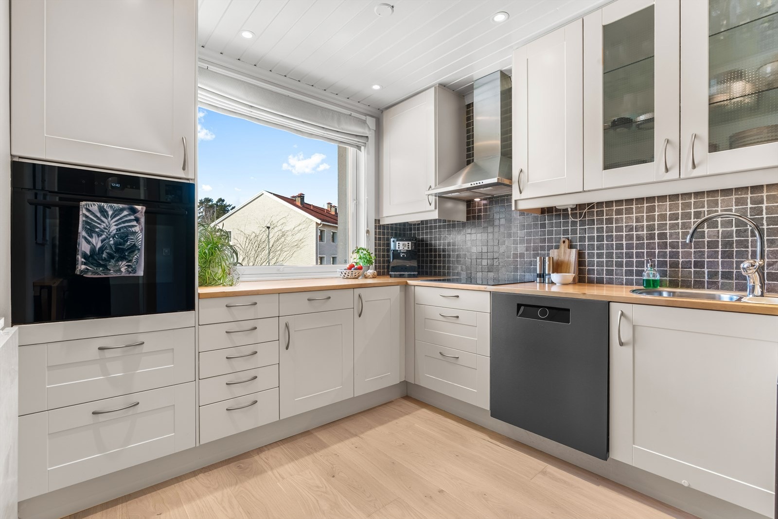 Pent og velutstyrt kjøkken med god skap- og benkeplass, samt downlights i taket. Galleribilde