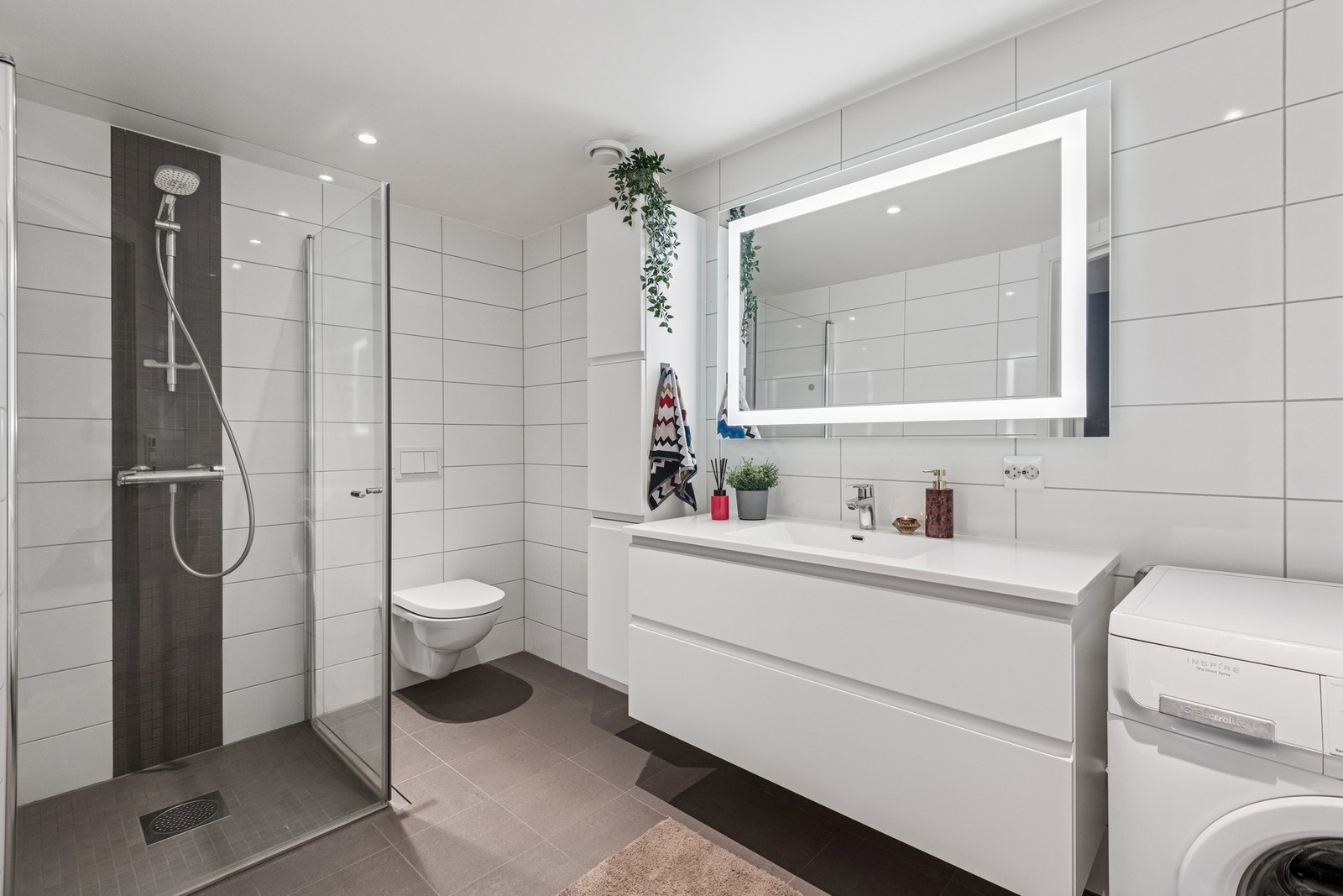 Moderne og flislagt bad med gulvvarme. God oppbevaringsplass i servant og høyskap. Galleribilde