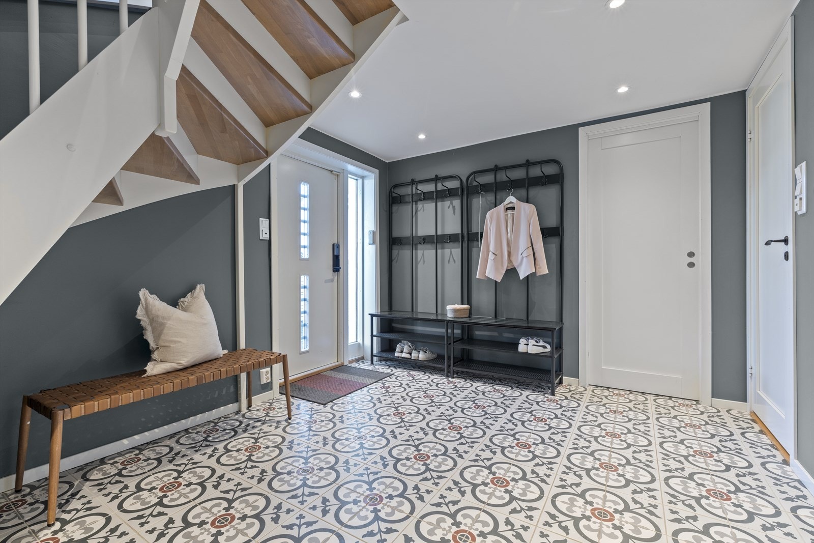 Trappen er en hvitmalt tretrapp fra 2018 med heltre inntrinn. Innfelt LED belysning i himling. Enkel oppbevaringsplass. El. folie under fliser på gulv. Galleribilde