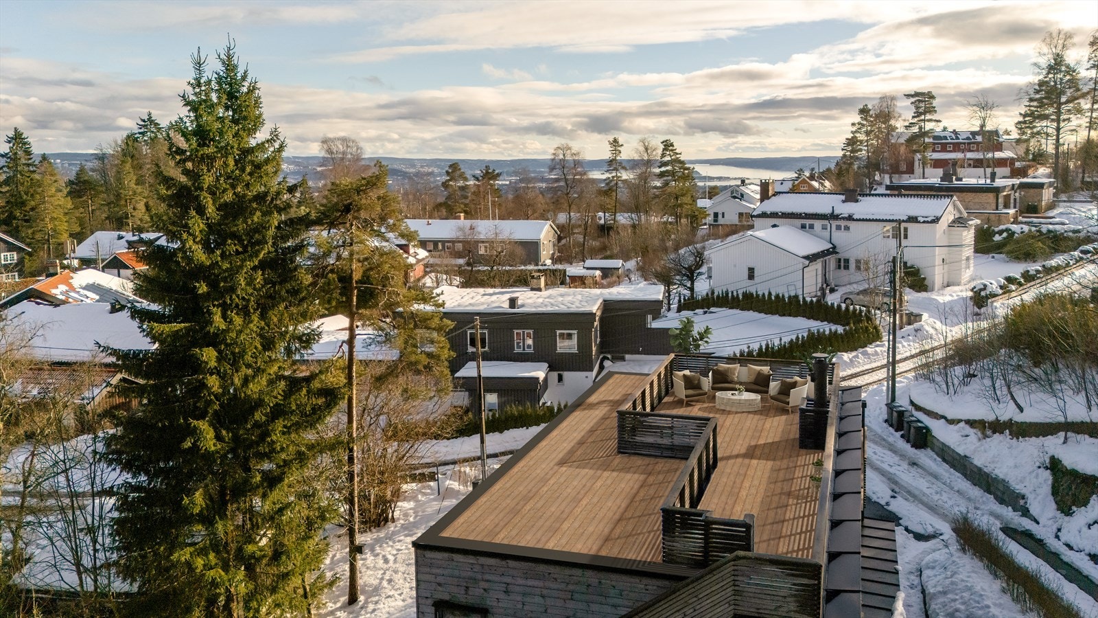 Takterrasse på hele 32 m² med fantastisk utsikt mot byen og fjorden. På bildet er det brukt digital styling med møblering og fjerning av snø. Avvik kan forekomme Galleribilde