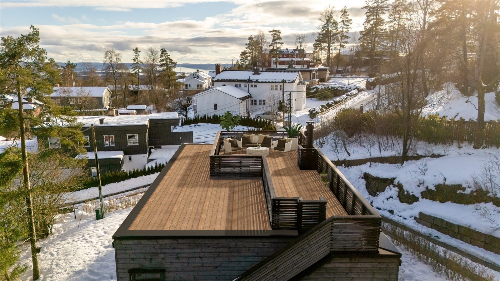 Takterrasse på hele 32 m² med fantastisk utsikt mot byen og fjorden. På bildet er det brukt digital styling med møblering og fjerning av snø. Avvik kan forekomme. Galleribilde