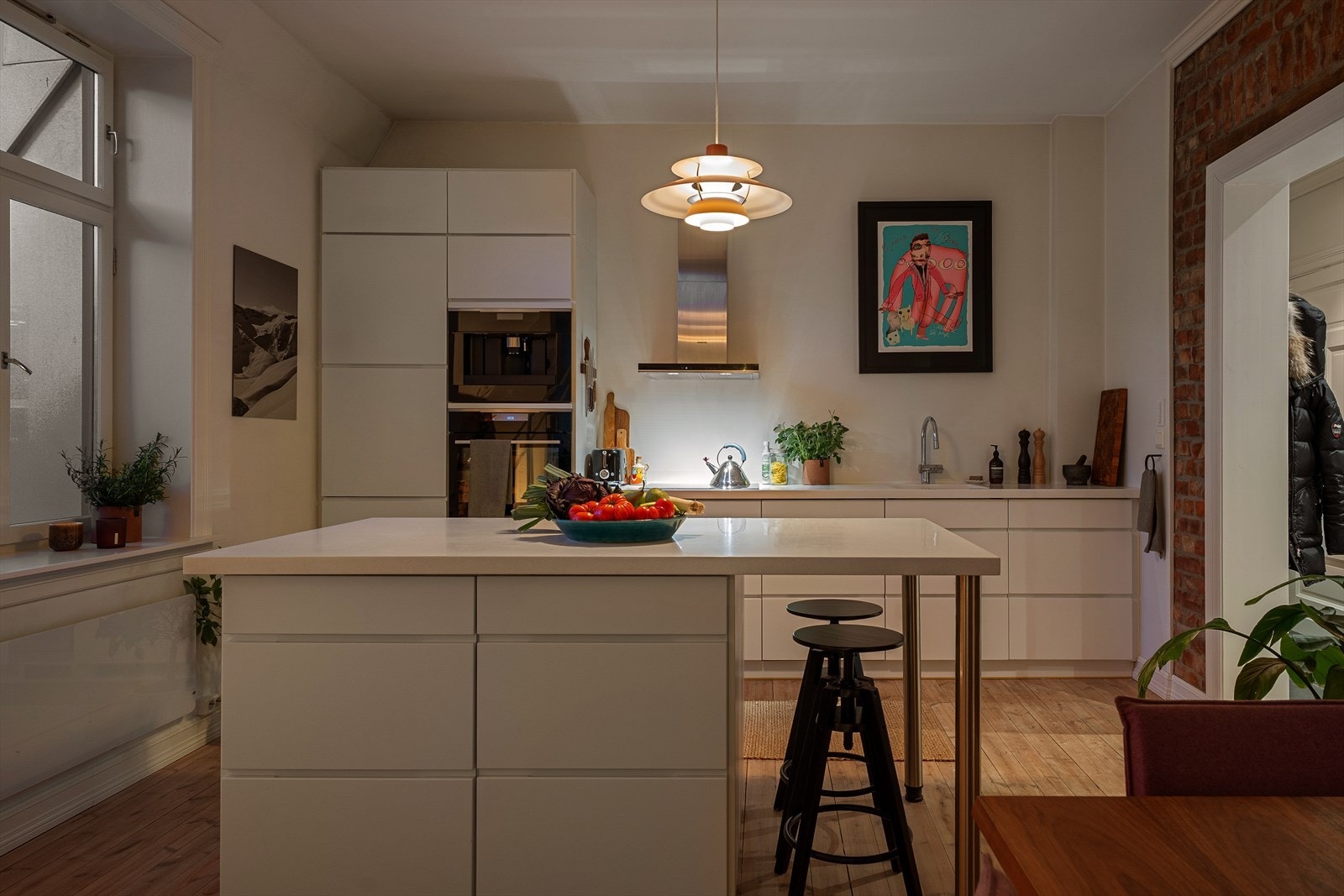 Lekkert Kvik-kjøkken med kjøkkenøy og Corian benkeplate. Avtrekksvifte med hette i børstet stål og Aquastop. Galleribilde