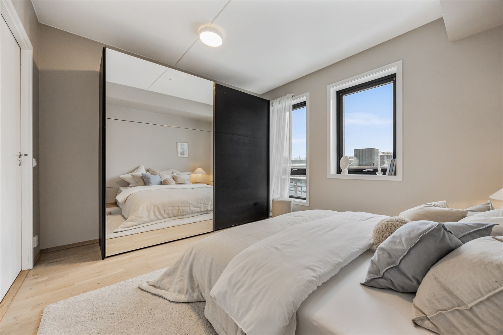 En stor skyvedørsgarderobe med speilfronter gir rikelig med oppbevaringsplass. Galleribilde