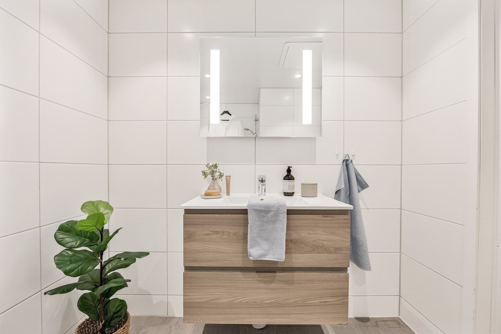 Baderomsinnredningen har en bred servant med skuffer og speilskap med integrert belysning. Galleribilde